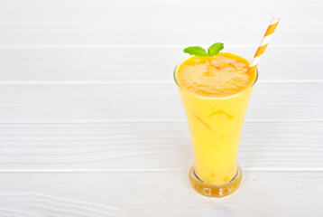 Mango smoothies yellow colorful fruit juice milkshake blend beverage healthy high protein the taste yummy In glass,drink to lose weight drink episode morning on white gray background.