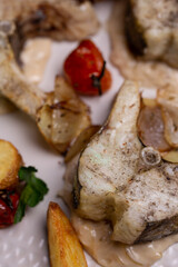 fish dishes in close - up . pieces of fish with potatoes on a plate