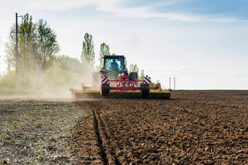 Fototapeta premium tractor during sowing in an open field on a sunny day