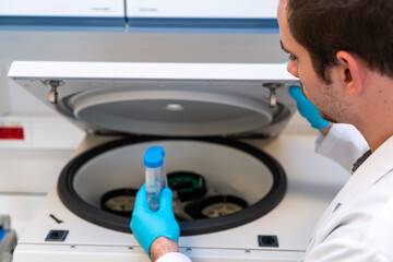Laboratory technician using refrigerated centrifuge machine in blood bank, Benchtop Centrifuges, ...