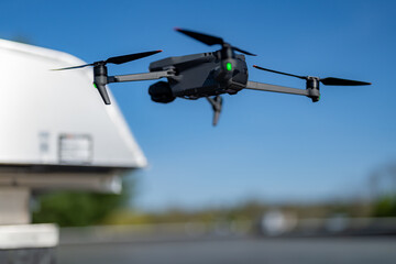 Drone being used to perform an aerial inspecting of HVAC RTU equipment on a commercial roof.