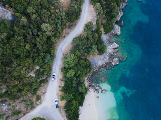 overhead view of car moving by road next to sea shore