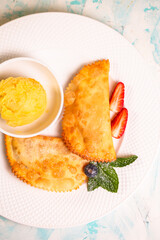 sweet berry cheburek with jam, ice cream and strawberries Top view