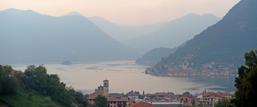 Panoramic evening view on Monte Isola and the small Isola di San Paolo in Lake Iseo as seen from Sulzano in Lombardy, Italy