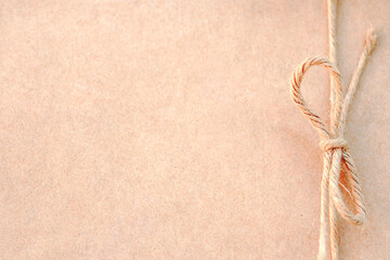 String or twine tied in a bow on kraft paper for photo background