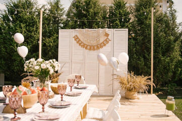 rustic outdoor birthday decor, table setting and photo zone