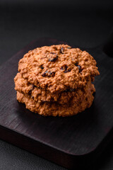 Delicious baked oatmeal raisin cookies on a dark concrete background