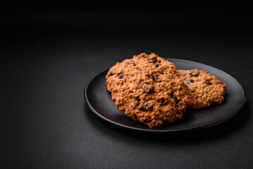 Delicious baked oatmeal raisin cookies on a dark concrete background