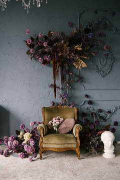 Vintage wooden armchair decorated with flower arrangements in the interior, luxury home design