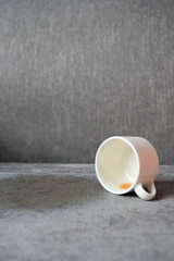 cup of coffee spilled on gray color sofa 