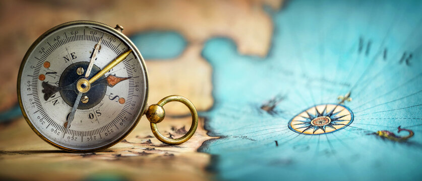 Magnetic old compass on world map. Travel, geography, navigation, tourism and exploration concept background. Macro photo. Very shallow focus.