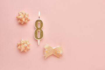 Number 8 on a pastel pink background with festive decorations. Happy birthday candles. The concept of celebrating a birthday, anniversary, important date, holiday. Copy space. banner