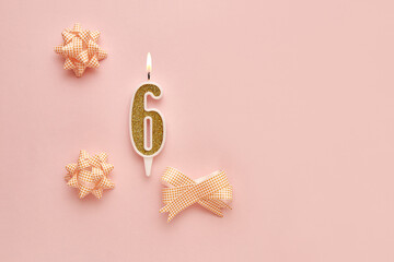 Number 6 on a pastel pink background with festive decorations. Happy birthday candles. The concept of celebrating a birthday, anniversary, important date, holiday. Copy space. banner