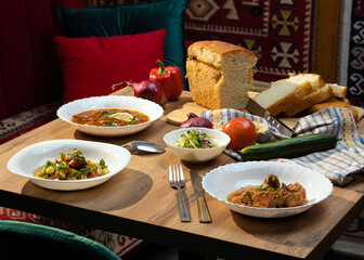 dining table with various food salads and snacks with fresh bread