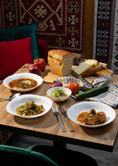dining table with various food salads and snacks with fresh bread