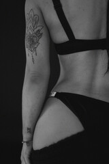 Beautiful athletic female body close-up in underwear black lingerie on a dark background