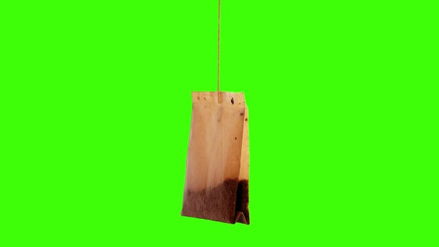 Single used teabag with brew on green screen