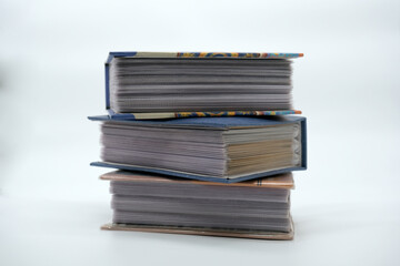 Photo albums stacked on a white background
