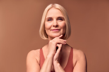Skin care and women's health. beautiful retired woman posing on a beige background.