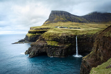 Fototapeta na wymiar Waterfall and cliffs in Gasadalur, Faroe Islands, Vagar island, Denmark