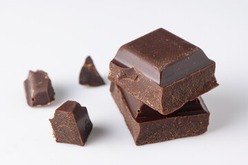 black chocolate pieces on white background side view