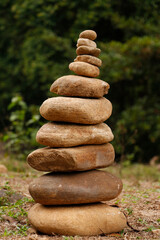 The pebbles stones are stacked in a pyramid against the natural background, The concept of harmony of balance and meditation