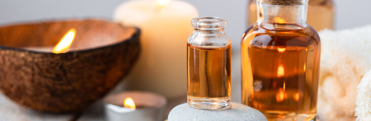 Concept of spa treatment in salon with pure organic natural oil. Atmosphere of relax, detention. Aromatherapy, candles, towel, wooden background. Skin care, body gentle treatment