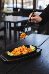 Asian cuisine. Shrimps with curry noodles. Appetizing dish on a dark background