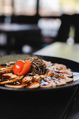 Sliced ​​meat with buckwheat noodles with teriyaki sauce. Restaurant serving food. Waiter, banquet.