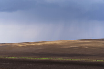 Pierwsza pozimowa burza nad polami wiosną, ziemia uprawna na Wschodniej Europie.