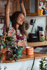 Young pregnant woman dancing to her favorite song.
