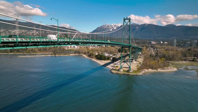 Lions gate bridge in Vancouver connecting from Stanley Park to North Van aerial shot sunny day mountains in the distance