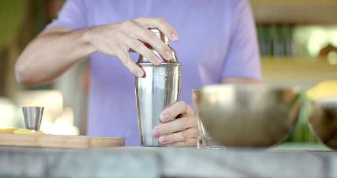 Close up of caucasian male barman preparing cocktails at beach bar