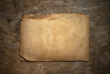 Photo of an old yellowed sheet of paper on a wooden background. Vintage test form.Antique document on the table.