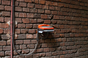 Old telephone on a brick wall, the concept of outdated technology
