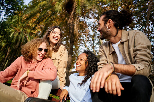 Happy cheerful people laughs in the park with multiracial friends friends. High quality photo