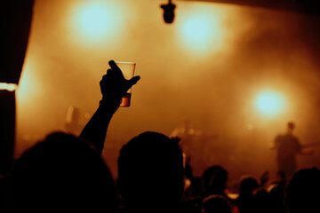 people dancing in the nightclub with a glass of beer raised