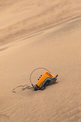 Obraz premium Vintage technology: old yellow walkman personal stereo cassette player resting on the sands of the desert (with big copy space)