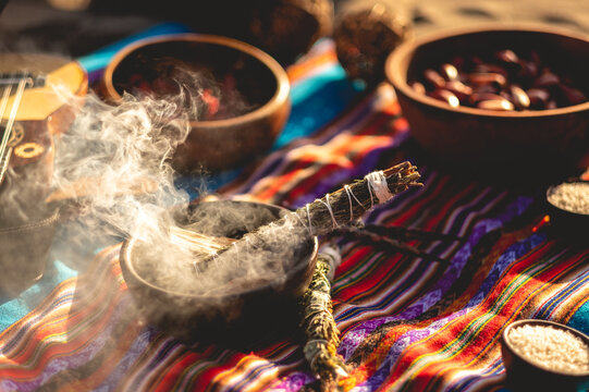Mystical andean journey: peruvian blanket, charango, crystals and burning holy wood incense in the desert sand