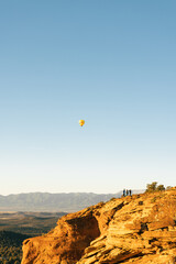 Three people observe hot air balloon in sky in Sedona Arizona.