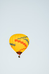 Naklejka premium Low angle view of yellow hot air balloon in Sedona Arizona isolated against light blue sky background in early morning.