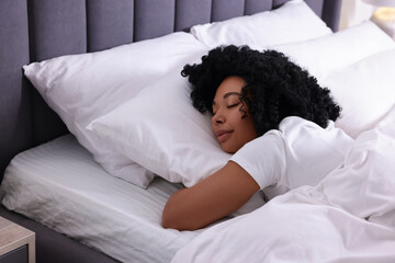 Beautiful young woman sleeping in soft bed