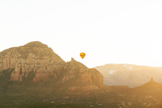 Sedona Arizona hot air balloon rises at sunrise for a group of tourists on vacation.