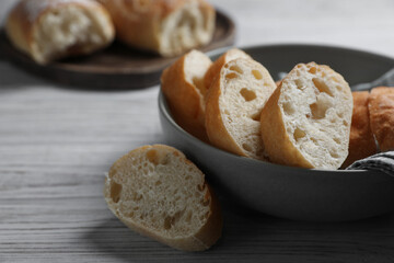 Fresh crispy ciabattas on white wooden table. Space for text
