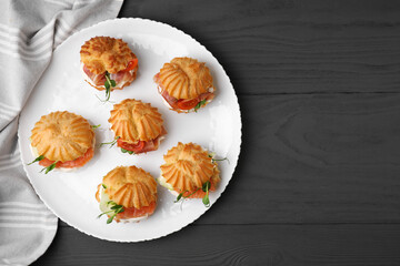 Delicious profiteroles with tasty filling on grey wooden table, top view. Space for text