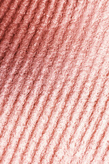 Corrugated rose gold texture as background, top view