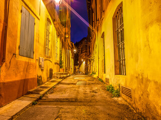 narrow night old street in a european city with lanterns