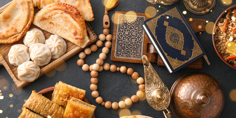 Traditional Eastern dishes with Quran, Aladdin lamp and tasbih on dark background