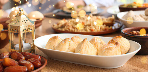 Traditional Arabic cookies with dates and fanoos lamp on dining table