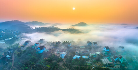 Aerial view of Xuan Tho suburbs near Da Lat city at morning with misty and sunrise sky. This place is considered most beautiful and peaceful place to watch sunrise in highlands of Vietnam